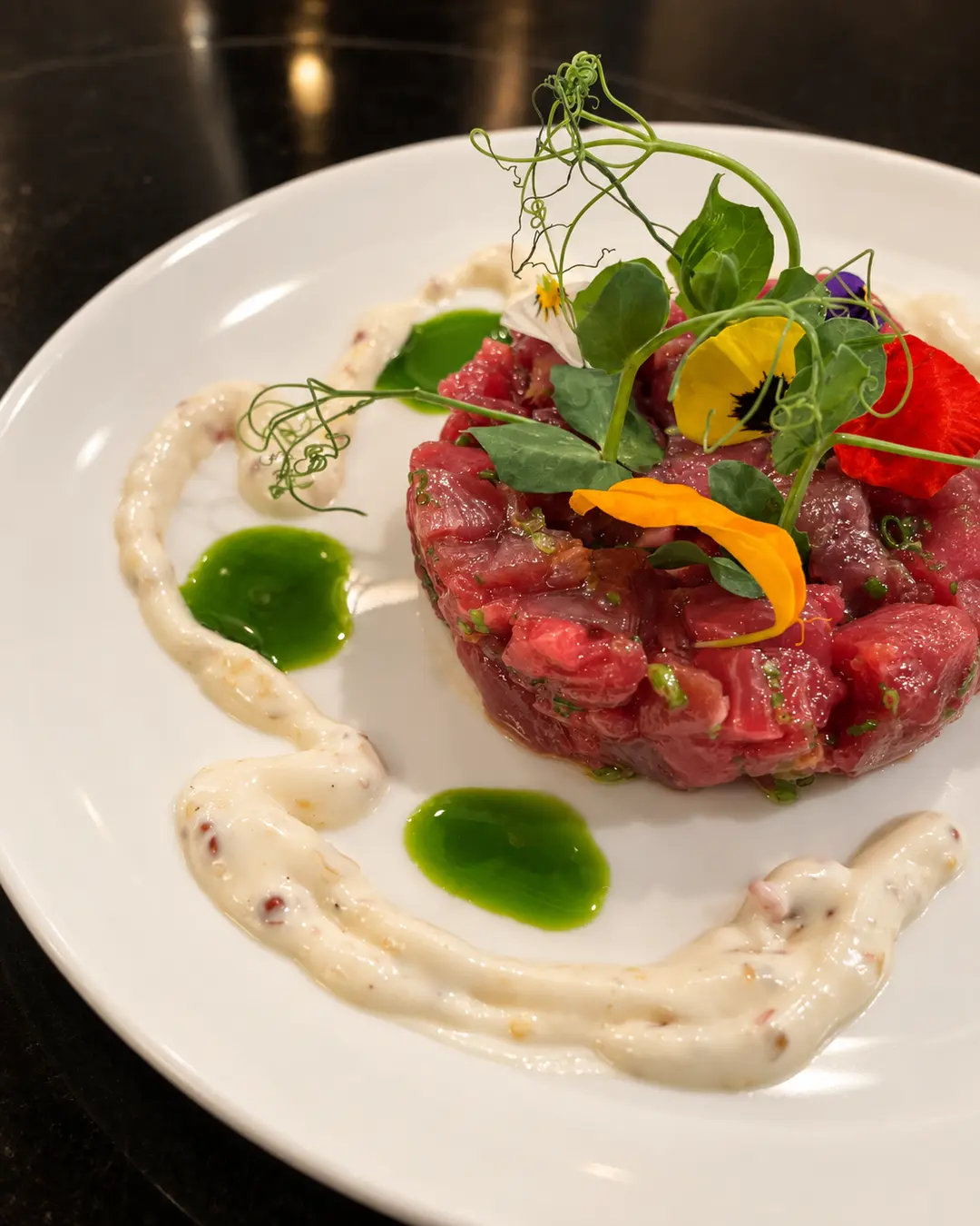 Angerichtetes Tatar mit frischen Kräutern